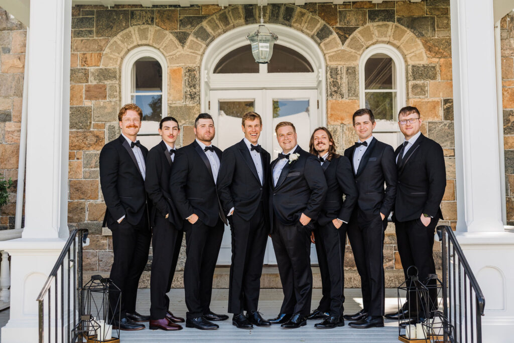 Groom and groomsmen lined up outside Brecknock Hall