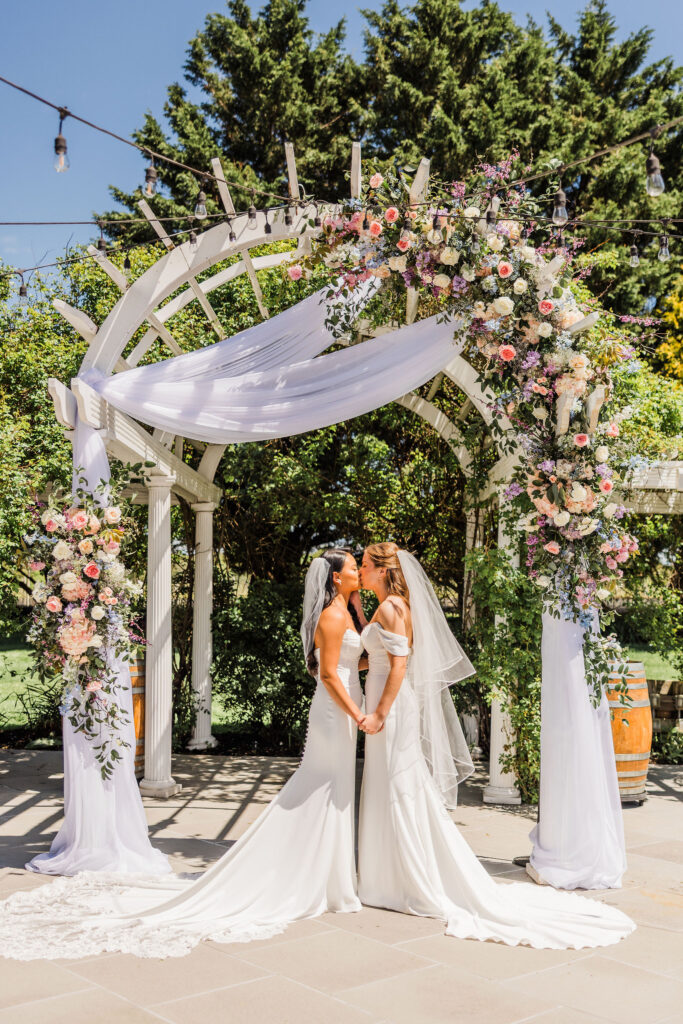 Brides kiss at Vineyards at Aquebogue wedding ceremony